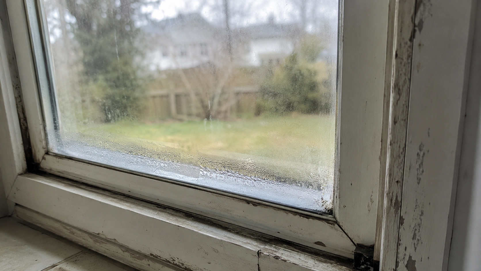 Old failing window with condensation between panes needing replacement in Tulsa OK