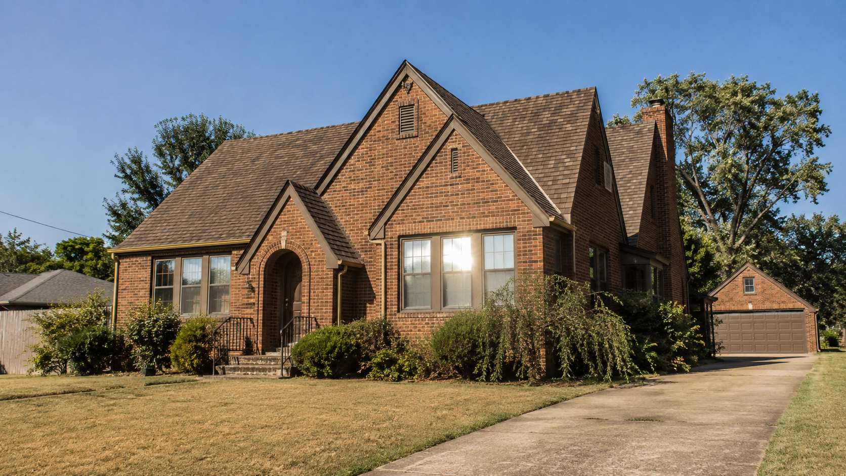 Summer sun beating on the west-facing windows of a brick Tulsa, Oklahoma home during an August heat wave